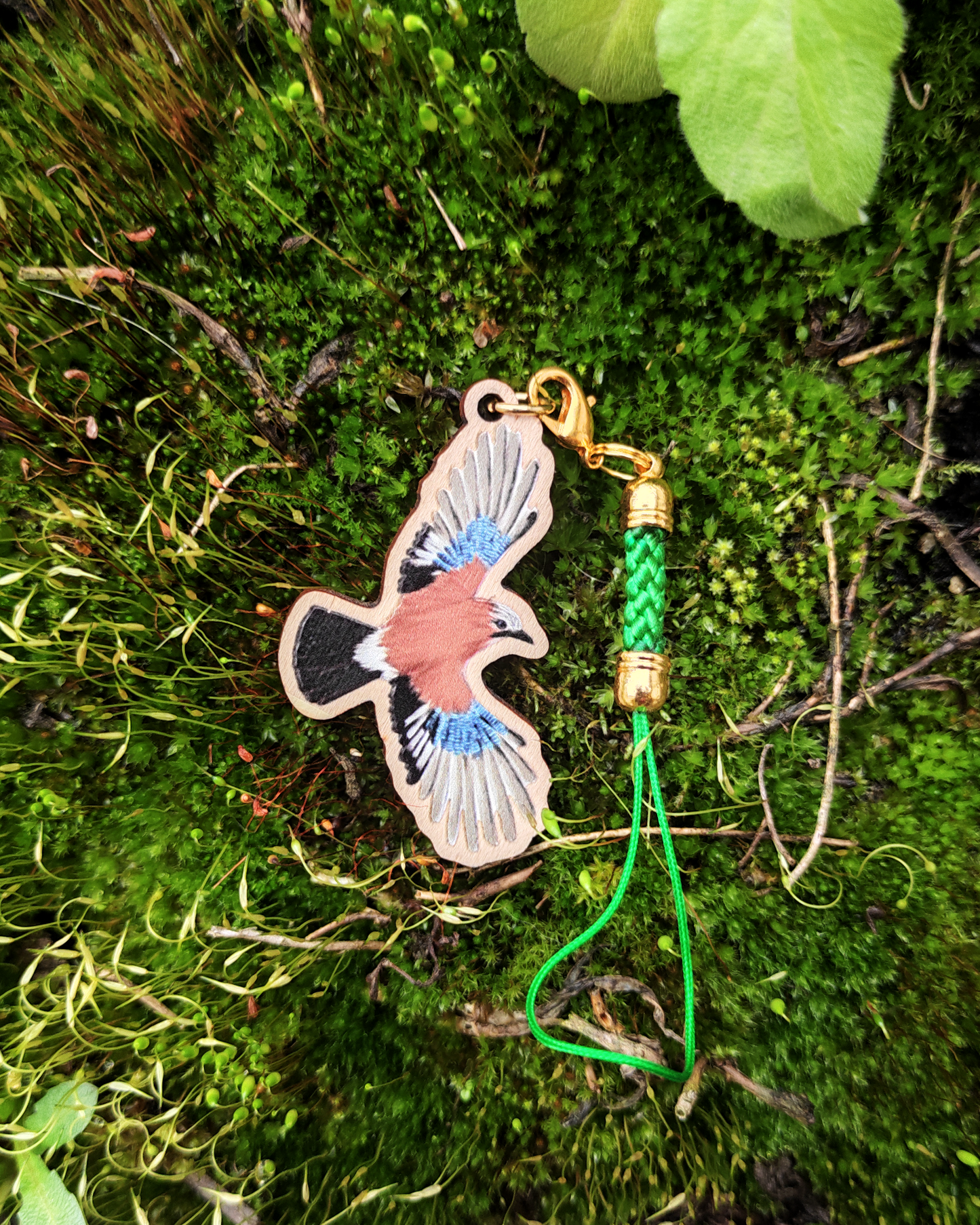 Wooden charm of a Eurasian Jay on moss.