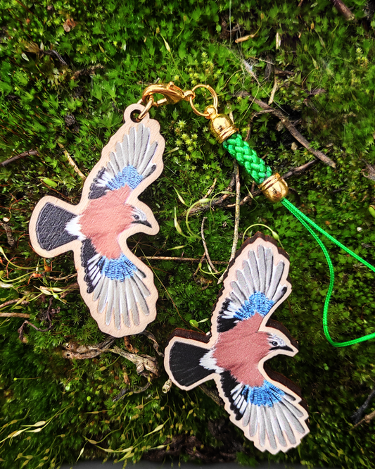 Wooden pin and charm of a Eurasian Jay on moss.