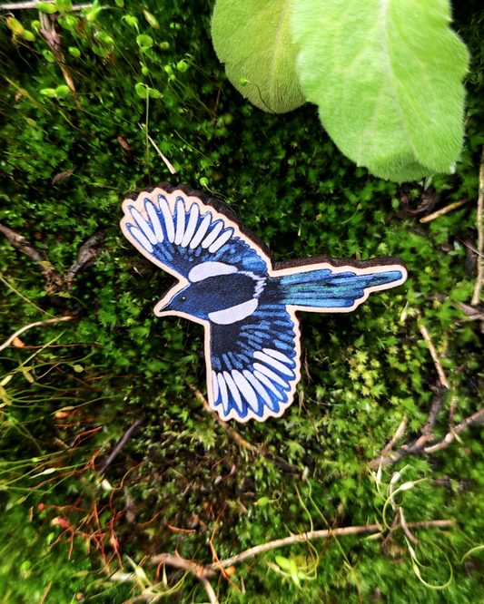 Wooden pin of a magpie on moss